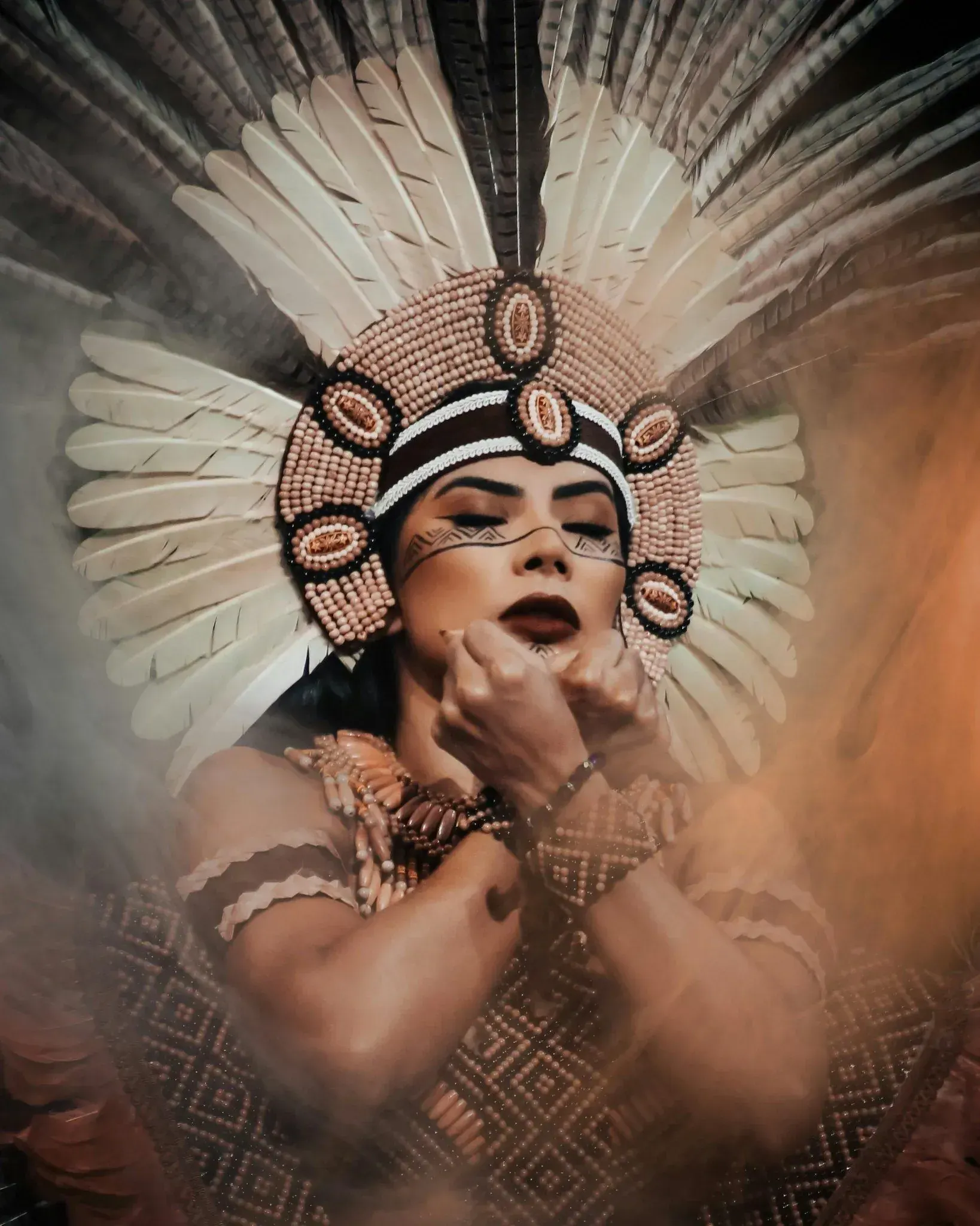 Mujer con tocado de plumas y pintura facial tradicional