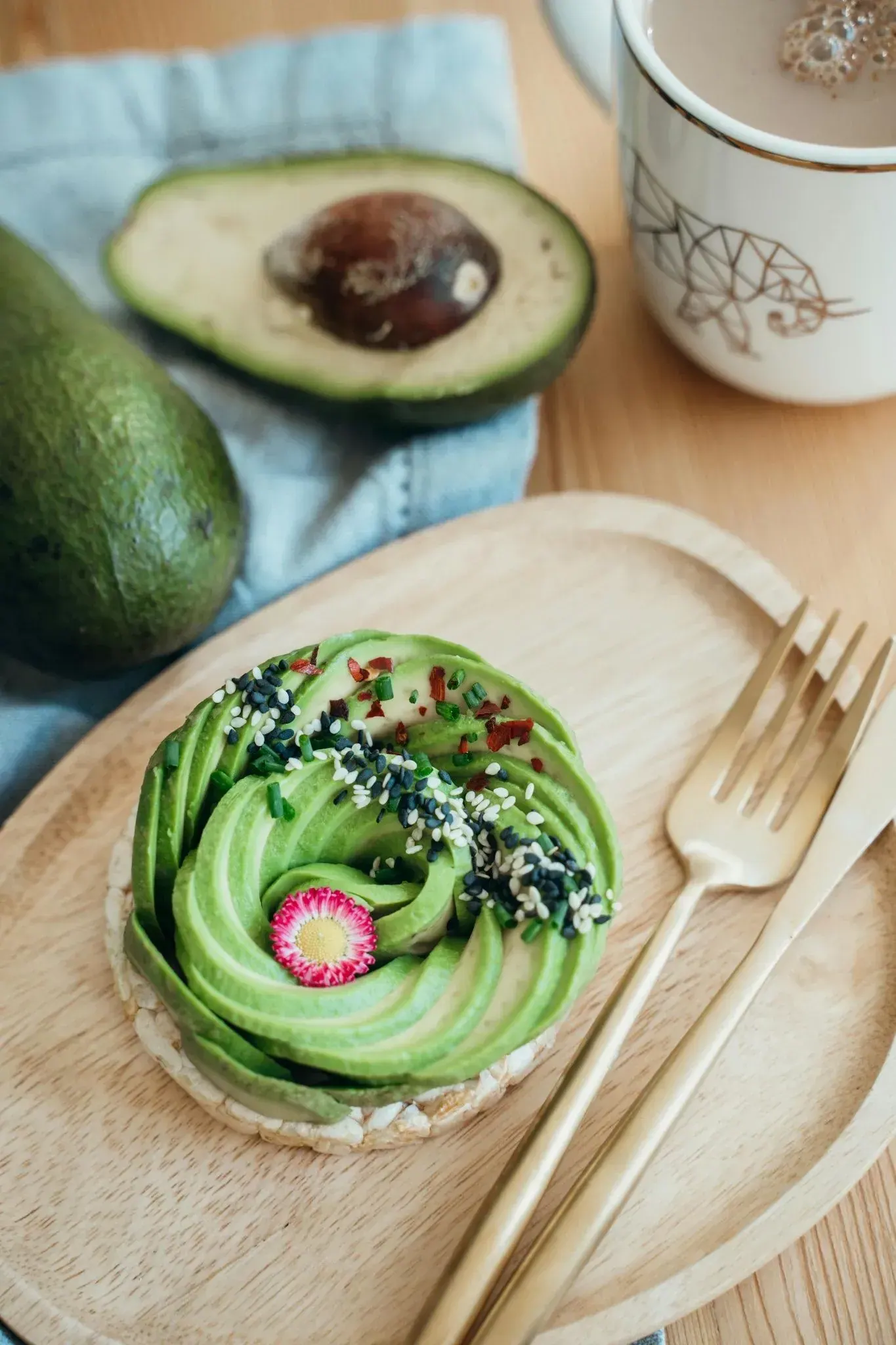 Tostada con palta y cubiertos sobre una tabla